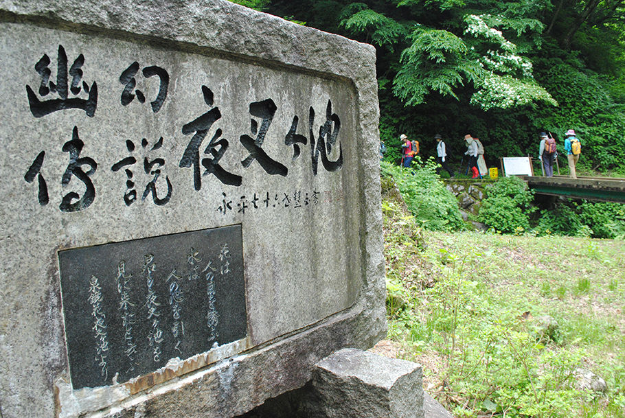 文学碑に見送られて歩く始めた登山者たち