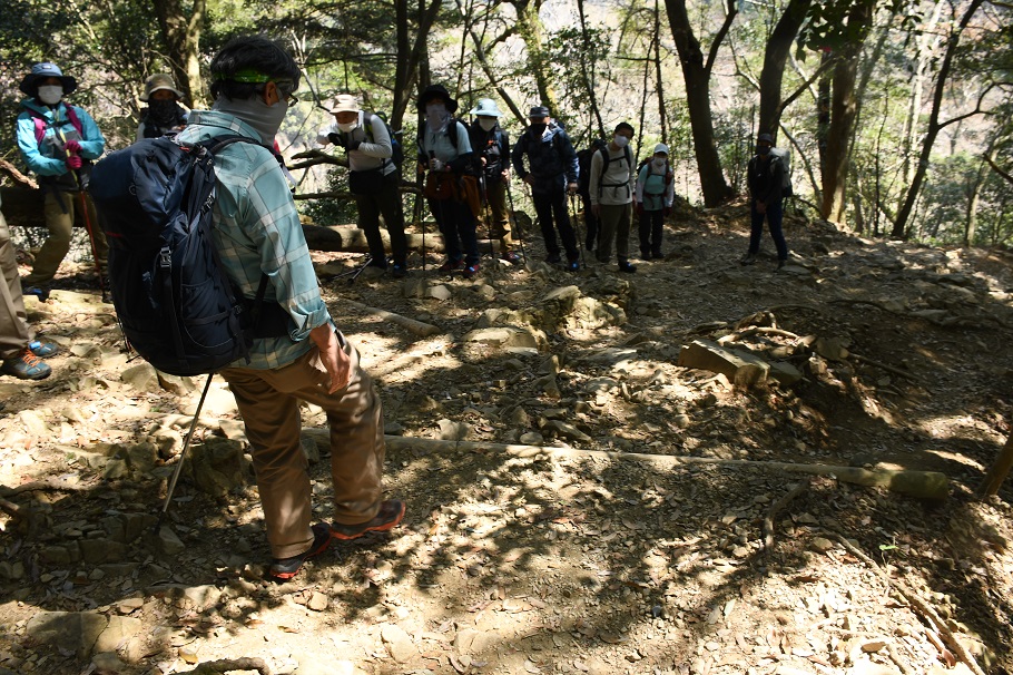 休憩中に登山道の歩き方を伝える太田ガイド