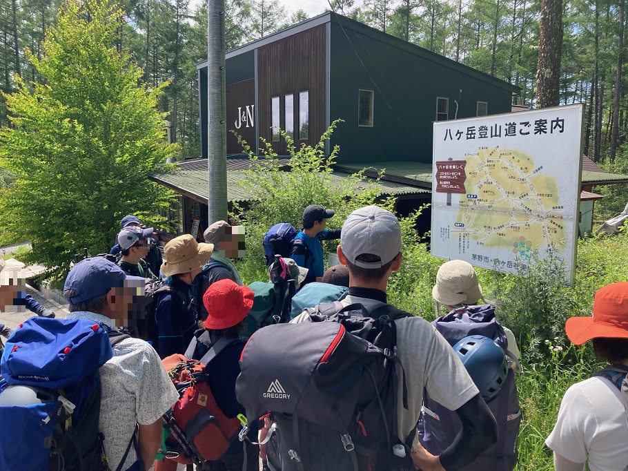 美濃戸口でルート説明をする髙山ガイド(奥の黒い帽子)