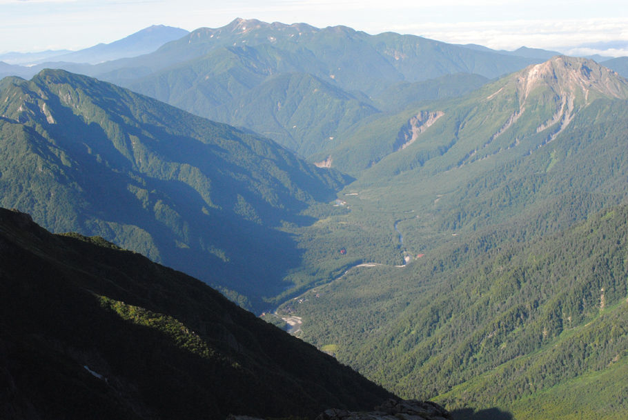 穂高連峰から上高地を見下ろす。中央に流れるのは梓川。右奥は焼岳。中央奥は乗鞍岳