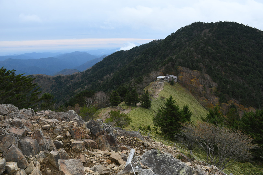 稜線から大菩薩峠を見る。建物は「介山荘」。左奥は奥多摩の山々