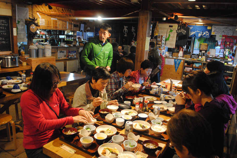 剣山頂上ヒュッテでの夕食風景。煮物や玉子焼きが並び、会話も弾む