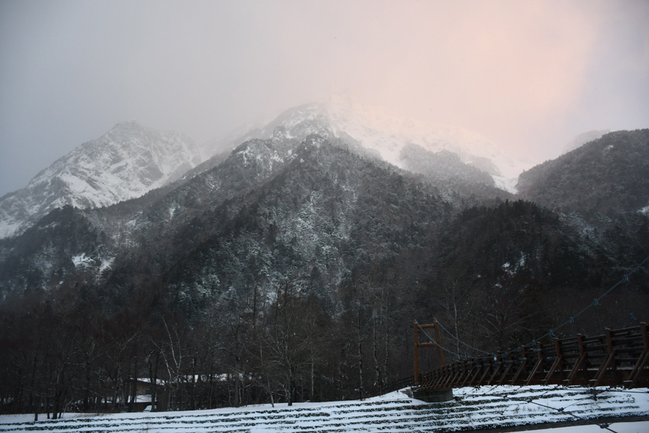 白雲に朝日があたる明神岳